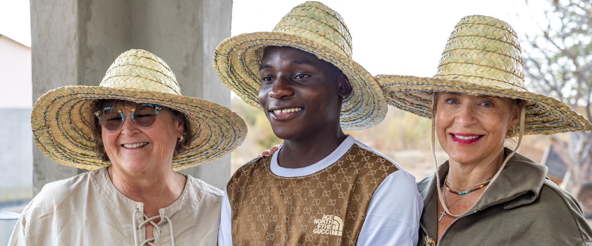 Emmanuel with Mrs. Bell (left) and a staff from the Amy Bell Charities.